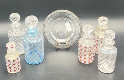 several glass bottles and a plate on a table with a silver plate
