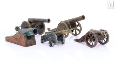 quatre types différents de canons jouets posés sur une surface blanche