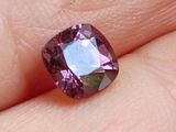 quelqu'un tient une pierre précieuse violette dans la main