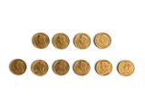 a close up of a number of gold coins on a white surface