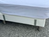 a white bed with a white sheet on top of it