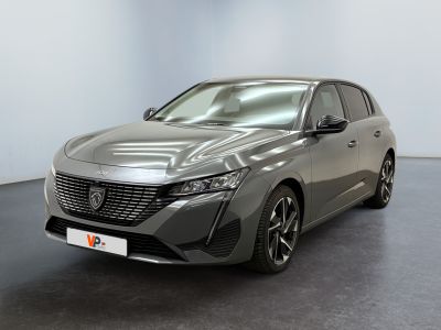 La voiture grise est garée dans une grande pièce au sol noir.