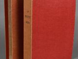 an open red book sitting on top of a table next to another book