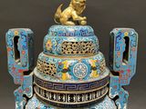 a blue and gold vase with a lion on top of it
