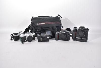 many cameras that are sitting on a white surface