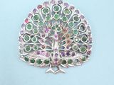 a close up of a brooch with a peacock on it