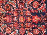 an image of a red and blue oriental rug on a wooden floor
