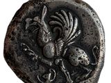 une vieille pièce d'argent sur laquelle figurent un oiseau et un crâne