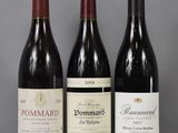 three bottles of wine are lined up on a glass table