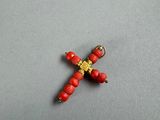 a close up of a cross made out of beads on a table