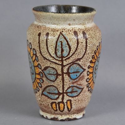 a vase with a design on it sitting on a table