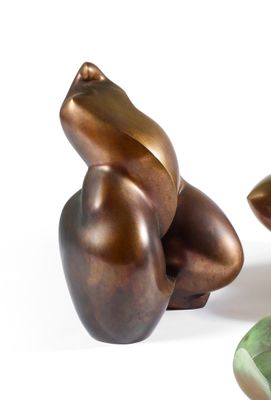 une sculpture en bronze représentant une grenouille assise sur une feuille
