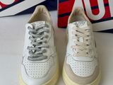 pair of white sneakers with red and blue logo on them