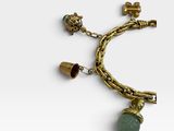 a close up of a gold bracelet with a green stone charm