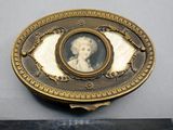 une assiette ancienne en or plaqué représentant le portrait d'une dame en robe blanche