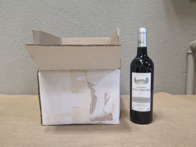 une bouteille de vin posée sur une table à côté d'une boîte