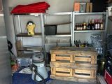 a room with a refrigerator, shelves, and other items in it