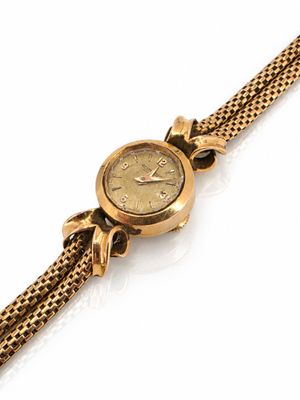 une image d'un gros plan d'une montre-bracelet sur une surface blanche