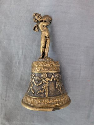 cloche en laiton ancien surmontée d'un petit garçon tenant une trompette