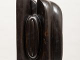 sculpture of a bookend on a white shelf with a white background