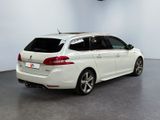 the rear end of a white car parked in a garage