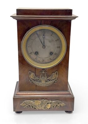 une horloge en bois posée sur une surface blanche