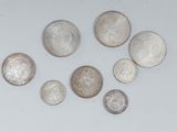 six different types of silver coins on a white surface