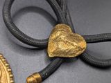 two pieces of gold and black rope with a gold heart on it