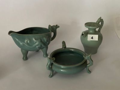 trois vases verts posés les uns à côté des autres sur une table