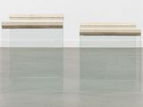 a pair of clear glass tables with wooden tops