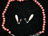 un gros plan d'un collier et de boucles d'oreilles posés sur une surface noire