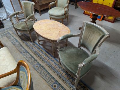 plusieurs chaises et une table dans une pièce dont le sol est recouvert d'un tapis