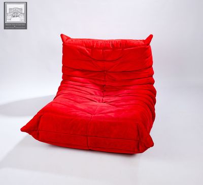 un pouf rouge posé sur un sol blanc