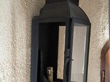a black lantern hanging on the wall next to a door
