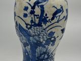 un vase bleu et blanc posé sur un support en bois