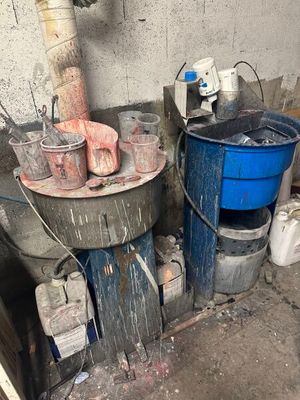 une photo d'une pièce sale avec des seaux et un chauffe-eau