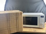 a microwave that is sitting on a table next to a box