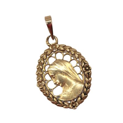 an image of a gold pendant with a woman ' s face in the center