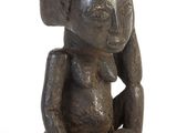 l'image d'une statue de femme assise sur un rocher