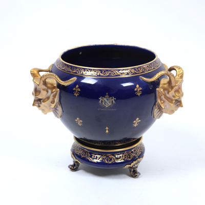a blue vase with gold decorations on it on a white surface