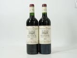 deux bouteilles de vin posées l'une à côté de l'autre sur une surface blanche