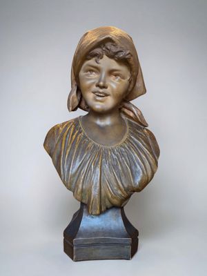 bronze bust of a young girl with a hat on her head