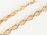 a close up of two gold chains on a white surface