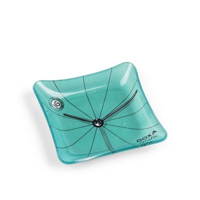 un plat carré en verre orné d'une horloge