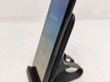 a close up of a cell phone on a stand on a table