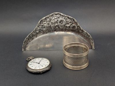 une horloge en argent et un porte-serviettes en argent posés sur une table