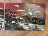 two paintings on the wall of a room with wood flooring