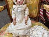 a doll that is sitting on a chair in a room