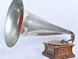 un gramophone argenté et rouge à côté d'une boîte en bois