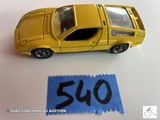 une petite voiture jaune posée à côté d'une étiquette de prix